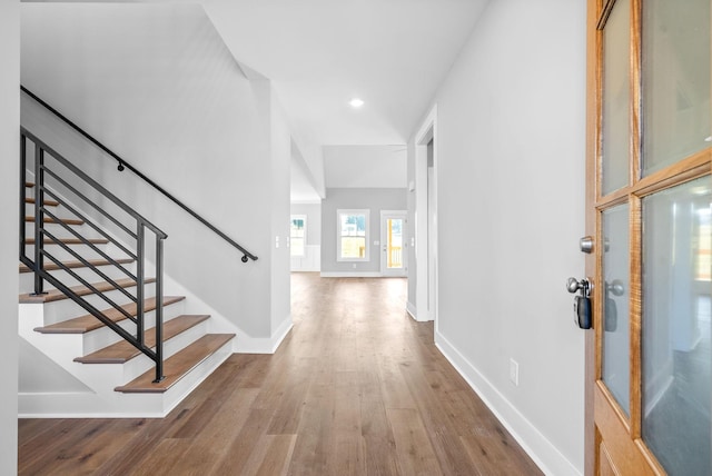 entryway with stairway, baseboards, and wood finished floors