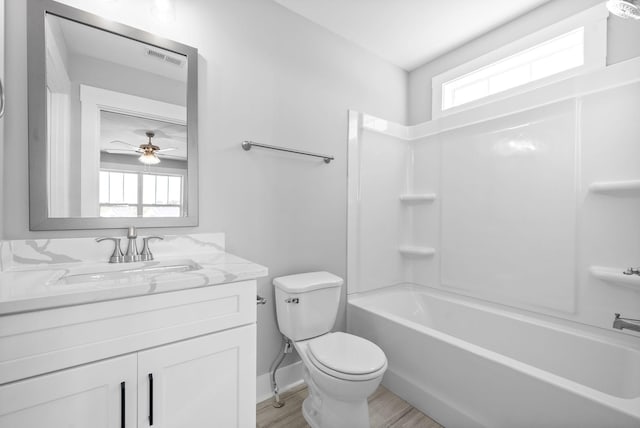 bathroom featuring plenty of natural light, toilet, vanity, and wood finished floors