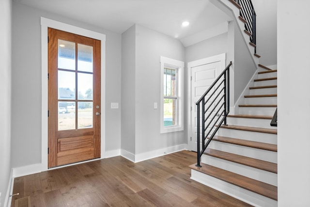 foyer with baseboards, a healthy amount of sunlight, and wood finished floors