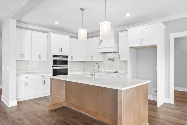 kitchen featuring light stone counters, dark wood-style floors, premium range hood, white cabinets, and crown molding