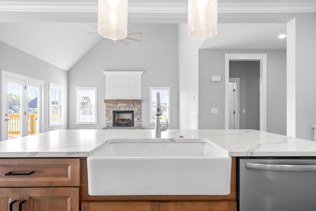 kitchen featuring a sink, open floor plan, a stone fireplace, light stone countertops, and dishwasher