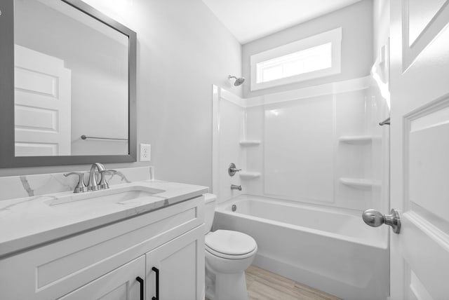 full bath featuring shower / bathing tub combination, toilet, wood finished floors, and vanity