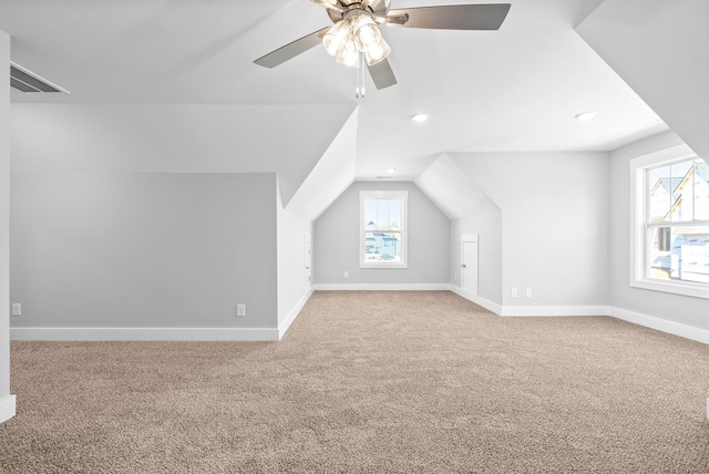 additional living space with a wealth of natural light, baseboards, lofted ceiling, and carpet