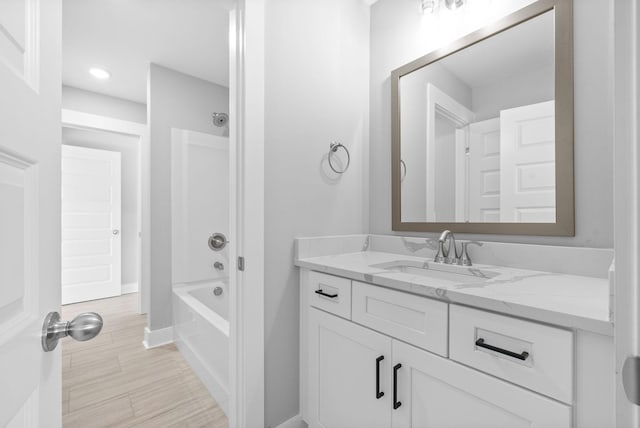 full bath with vanity, bathing tub / shower combination, baseboards, and wood finished floors