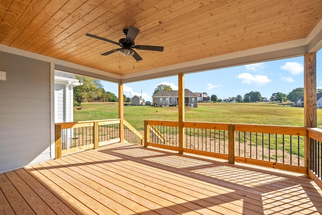 wooden terrace featuring a yard and a ceiling fan