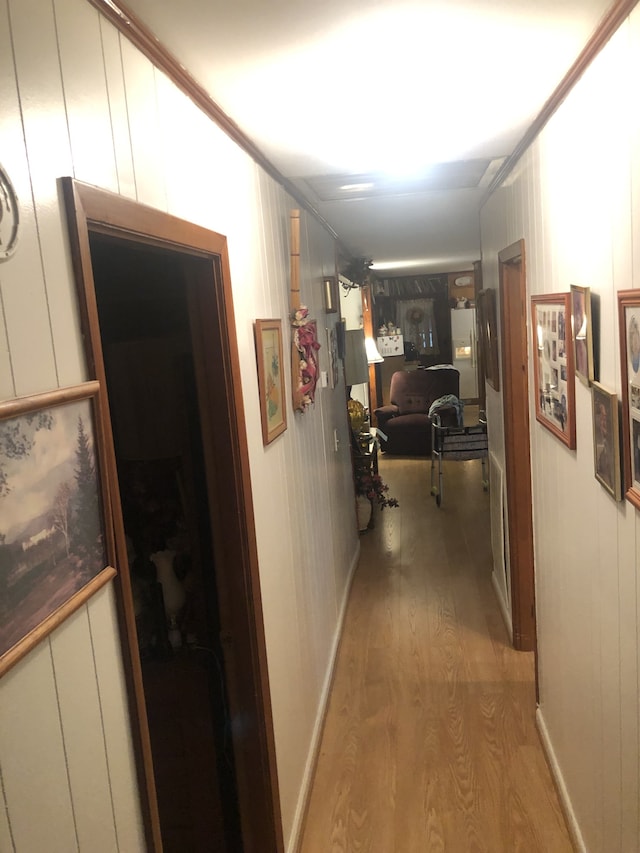 hallway featuring wood-type flooring and crown molding