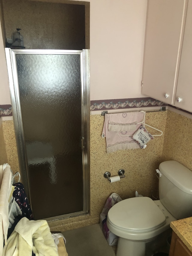 bathroom with walk in shower, vanity, and toilet