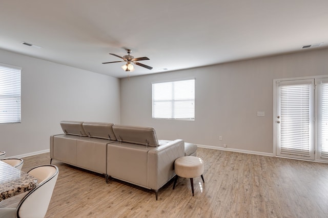 living room featuring light hardwood / wood-style floors and ceiling fan