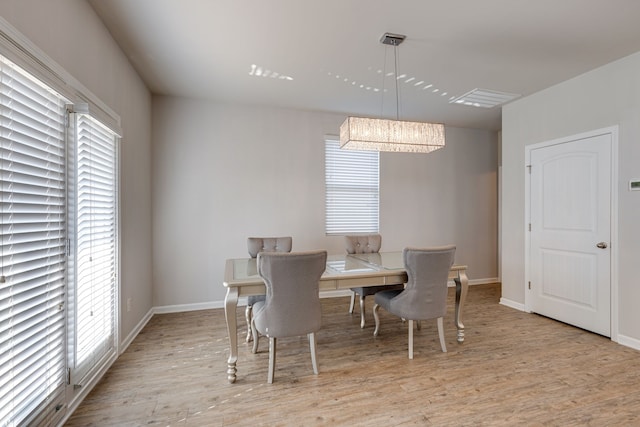 dining space with a notable chandelier, light hardwood / wood-style floors, and a wealth of natural light