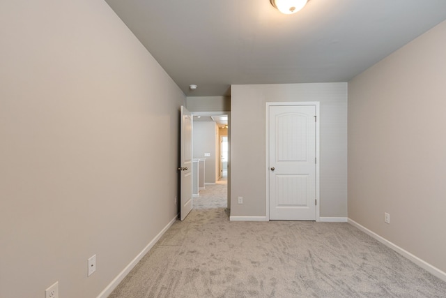 unfurnished bedroom with a closet and light colored carpet