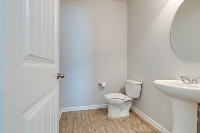 bathroom featuring wood-type flooring, sink, and toilet