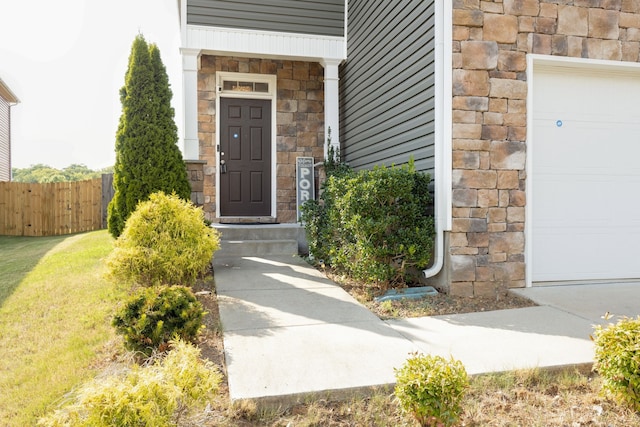 property entrance featuring a yard and a garage