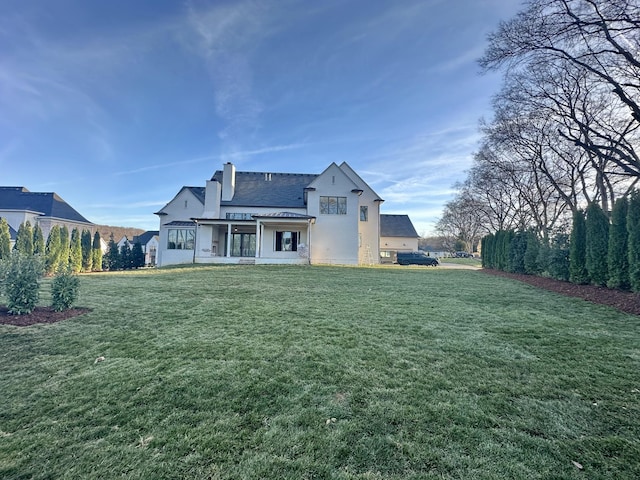 rear view of property with a lawn