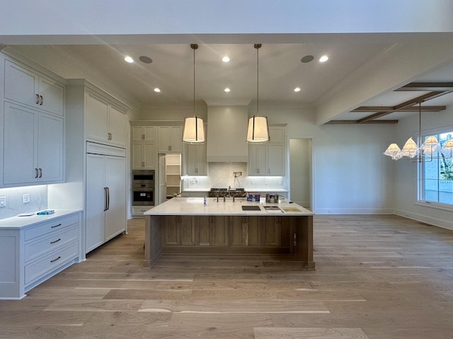 kitchen with decorative light fixtures, light hardwood / wood-style flooring, paneled fridge, a large island, and decorative backsplash