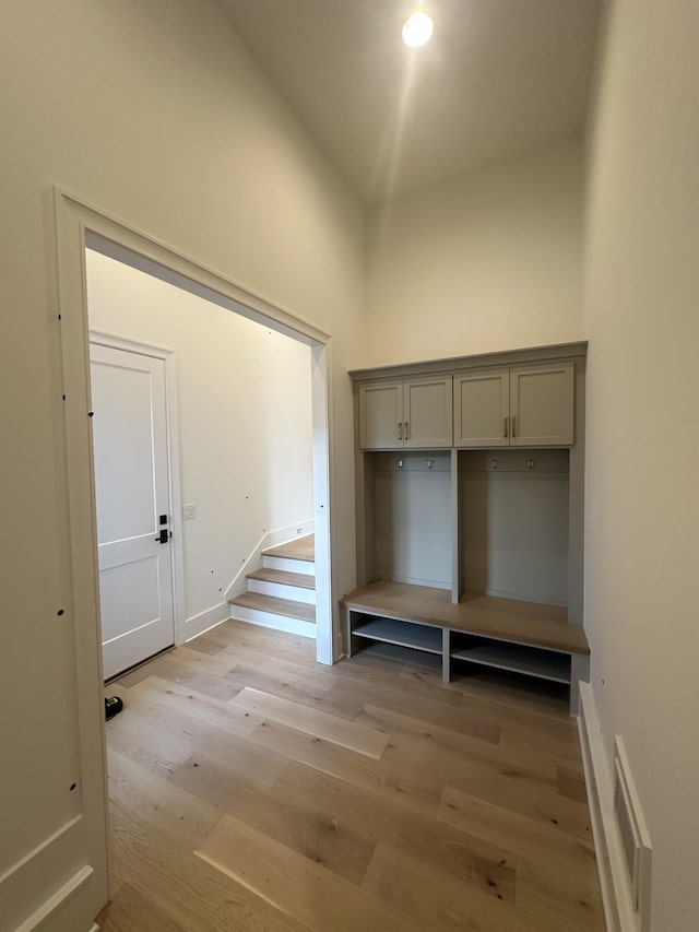 mudroom featuring a high ceiling and light wood-type flooring