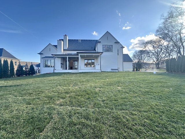 rear view of house with a patio and a lawn