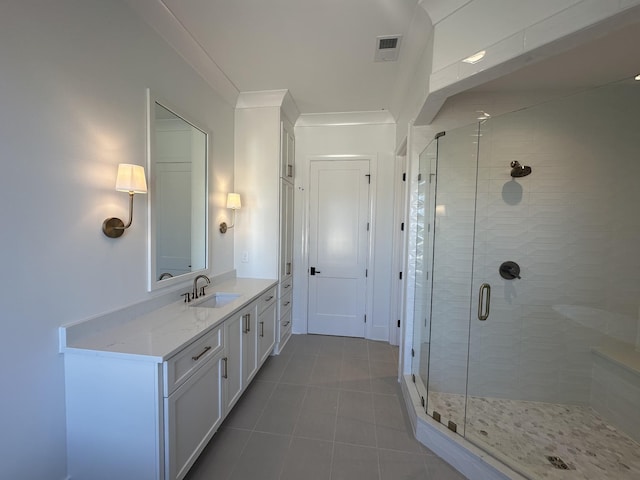 bathroom featuring tile patterned flooring, crown molding, vanity, and a shower with shower door