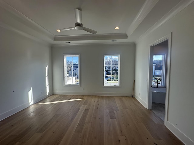 unfurnished room with crown molding, ceiling fan, a raised ceiling, and light hardwood / wood-style floors