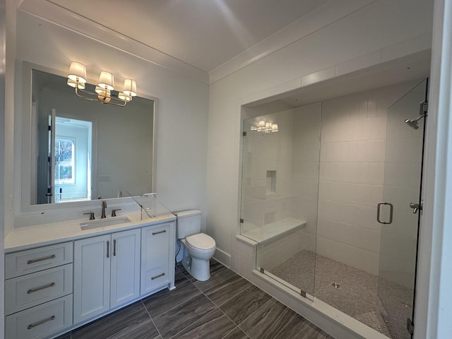 bathroom with vanity, ornamental molding, a shower with door, and toilet