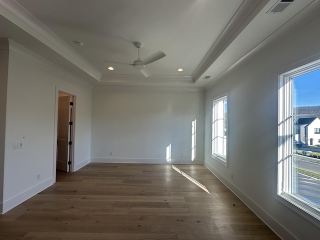 unfurnished room featuring a raised ceiling, ornamental molding, dark hardwood / wood-style floors, and ceiling fan