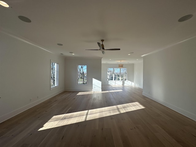 unfurnished living room with crown molding, ceiling fan, and dark hardwood / wood-style flooring