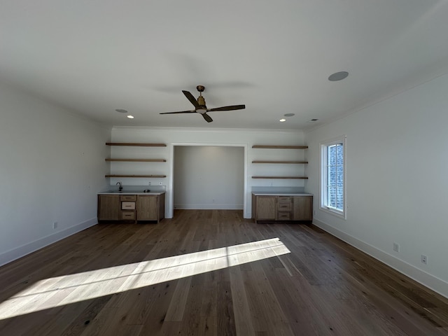 unfurnished living room featuring dark wood-type flooring, ceiling fan, and ornamental molding