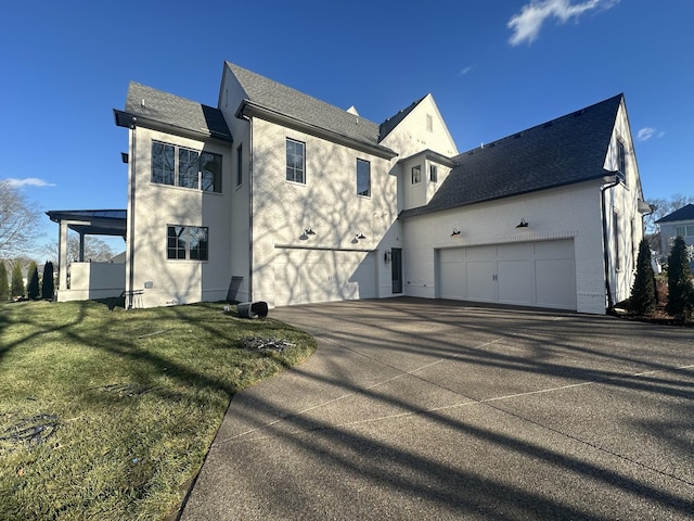 rear view of house featuring a garage and a lawn