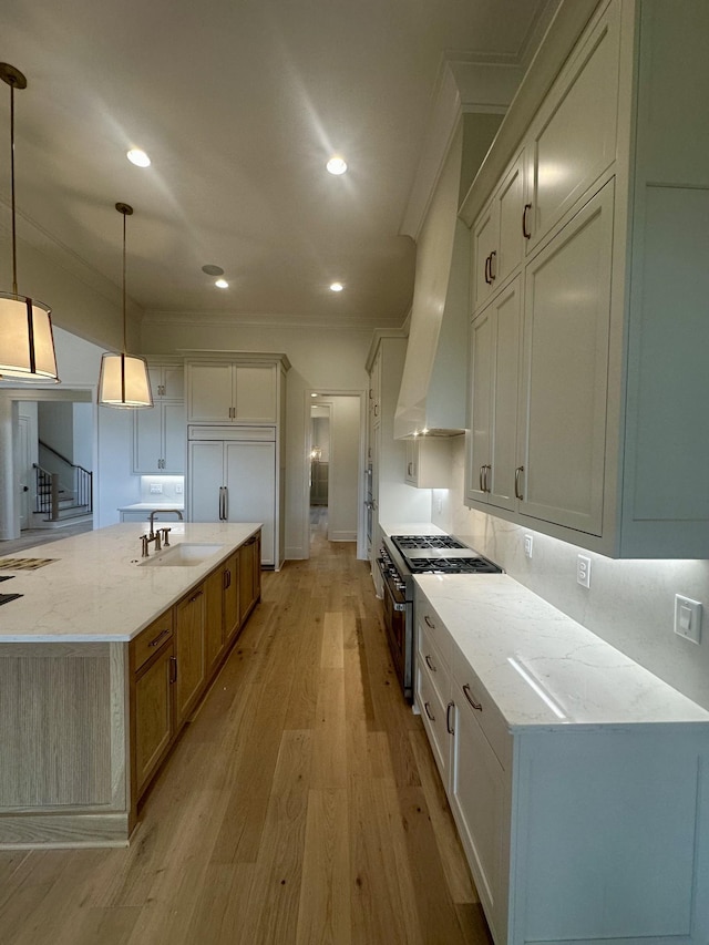 kitchen with high quality appliances, light stone countertops, sink, and hanging light fixtures