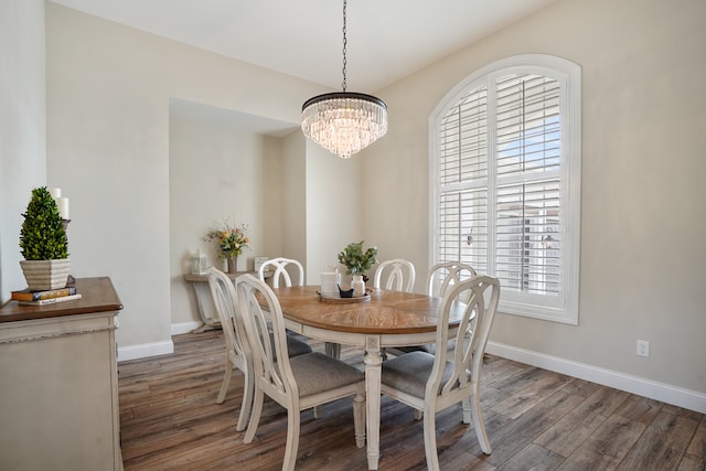 dining space featuring dark hardwood / wood-style flooring and a chandelier