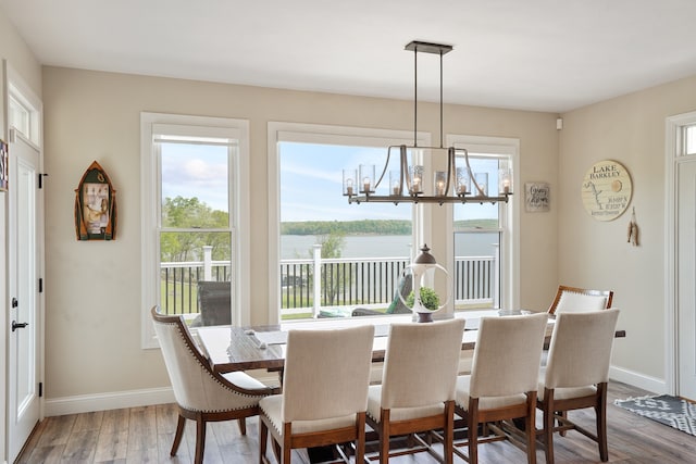 dining area with light hardwood / wood-style flooring and a notable chandelier