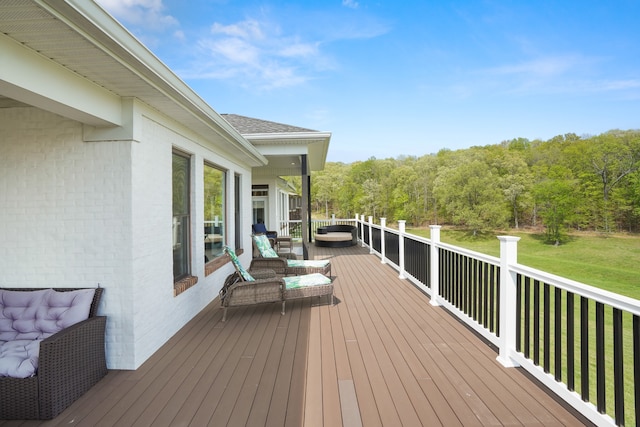 deck with an outdoor living space and a lawn