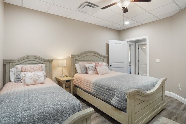 bedroom featuring a paneled ceiling, ceiling fan, and dark wood-type flooring