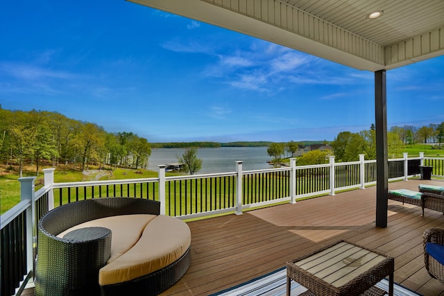 deck with a water view and a lawn