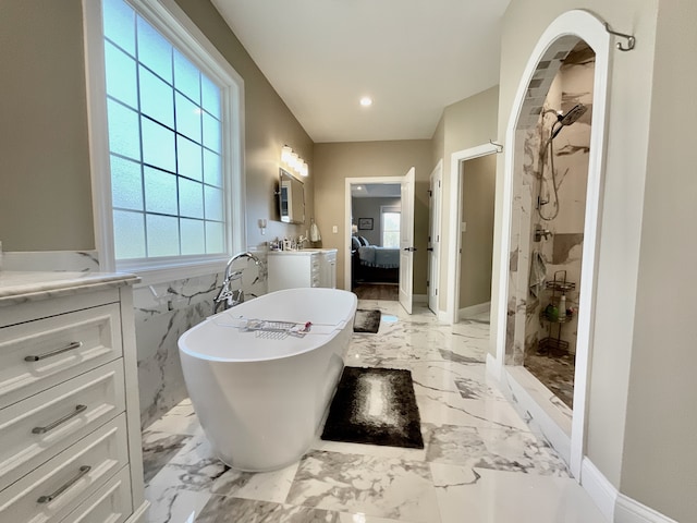 bathroom with tile flooring, independent shower and bath, oversized vanity, and tile walls