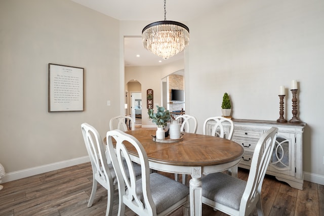 dining room featuring an inviting chandelier and dark wood-type flooring