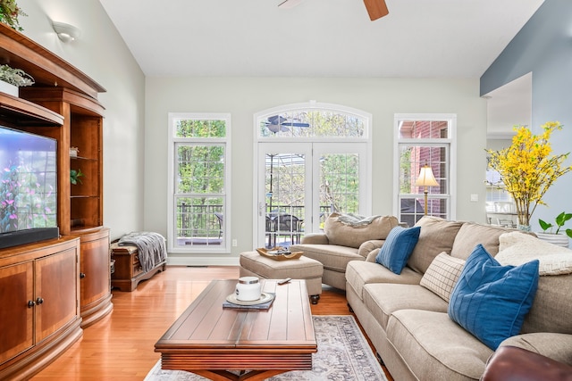 living room with a healthy amount of sunlight, light hardwood / wood-style floors, ceiling fan, and lofted ceiling