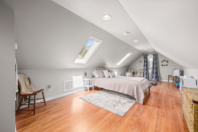 bedroom with vaulted ceiling with skylight and light wood-type flooring