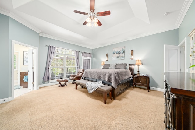 carpeted bedroom featuring ornamental molding, connected bathroom, ceiling fan, and a tray ceiling