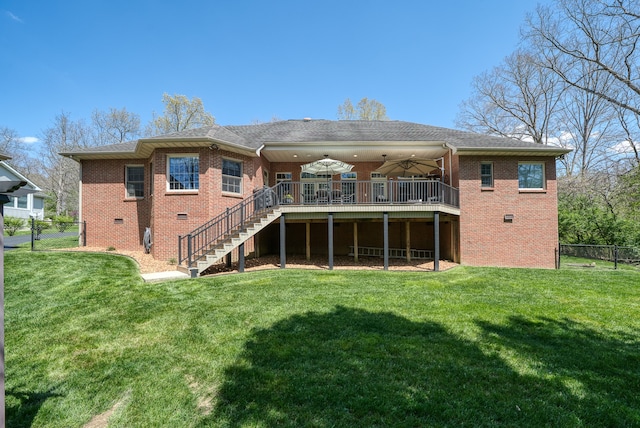 back of property with a deck and a lawn