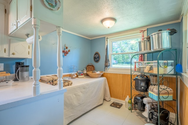 bedroom featuring a textured ceiling, light tile floors, and ornamental molding