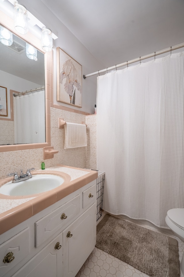 bathroom with tile flooring, vanity, and toilet