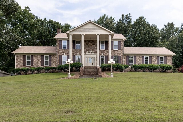 greek revival inspired property with a front lawn