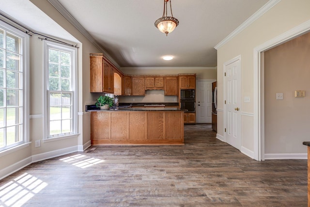 kitchen with dark wood finished floors, dark countertops, ornamental molding, a peninsula, and black appliances