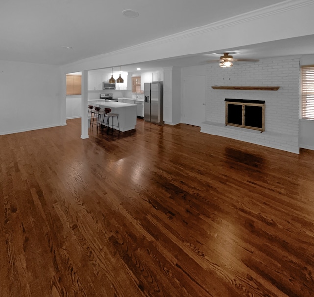 unfurnished living room featuring ceiling fan, hardwood / wood-style flooring, and a fireplace