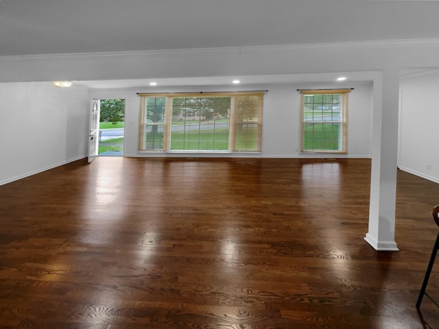 spare room with dark hardwood / wood-style flooring, plenty of natural light, and crown molding