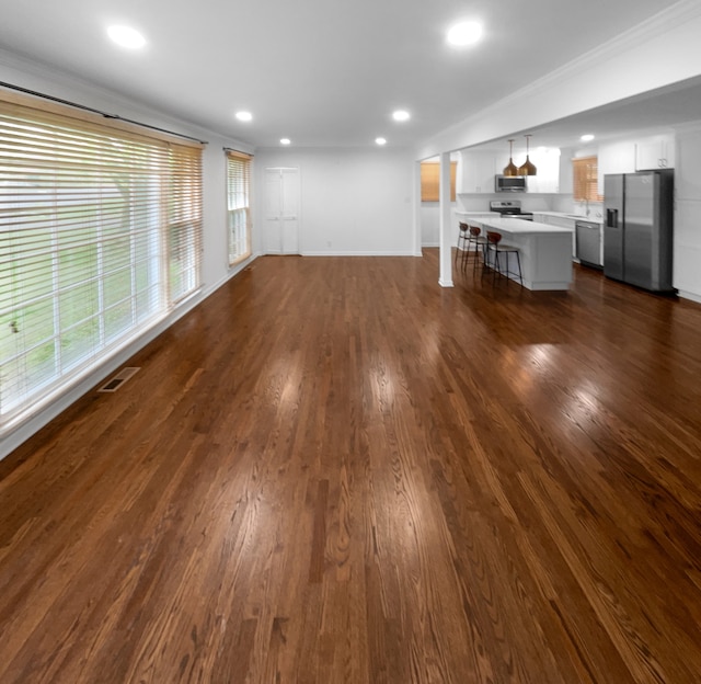 unfurnished living room with dark hardwood / wood-style floors and a wealth of natural light