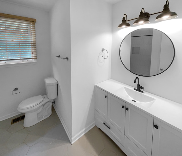 bathroom with tile floors, vanity, and toilet