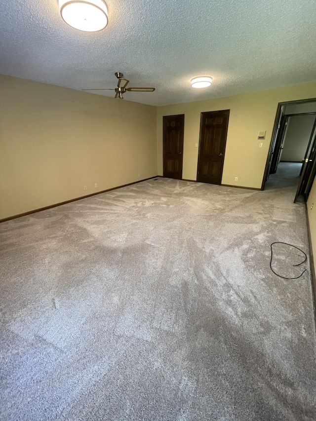 carpeted spare room featuring ceiling fan and a textured ceiling