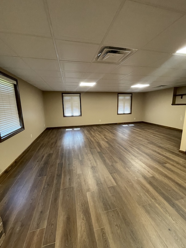 spare room with a paneled ceiling, hardwood / wood-style floors, and a healthy amount of sunlight