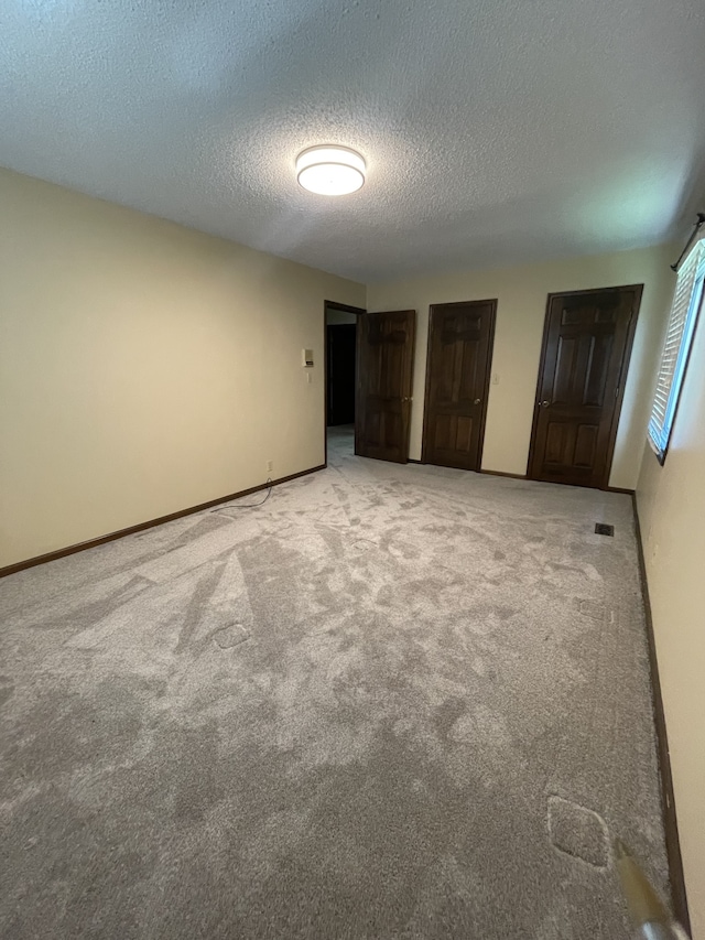 unfurnished bedroom with carpet floors and a textured ceiling